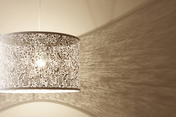 biała lampa wisząca w stylu nowoczesnym, klosz z ażurowego metalu