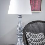 wysoka lampa stołowa z białym abażurem, szara podstawa z barwionego szkła - aranżacja